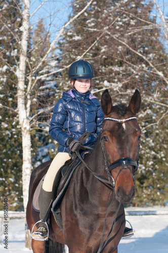 Ten years girl riding a horse in winter
