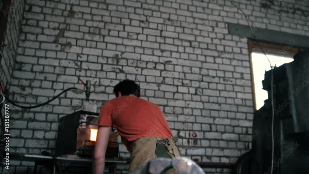 Muscular blacksmith working in forge - making metal knife by hammer Muscular blacksmith working in forge - making metal knife by hammer