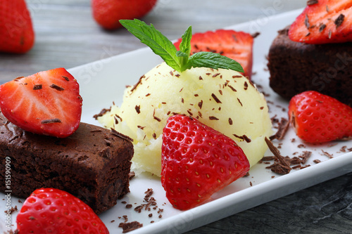 gelato con fragole e dolce al cioccolato su sfondo grigio