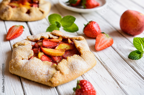 Traditional French Galette pie filled with strawberry and peach