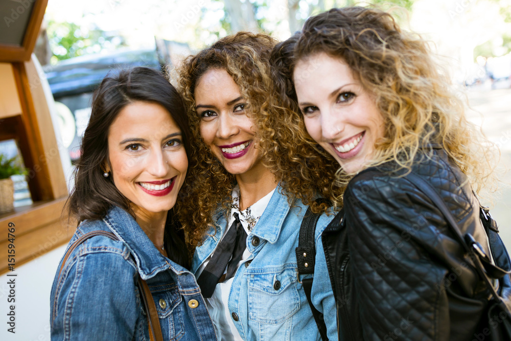 Three beautiful young women looking at camera in the street. Three beautiful young women looking at camera in the street.