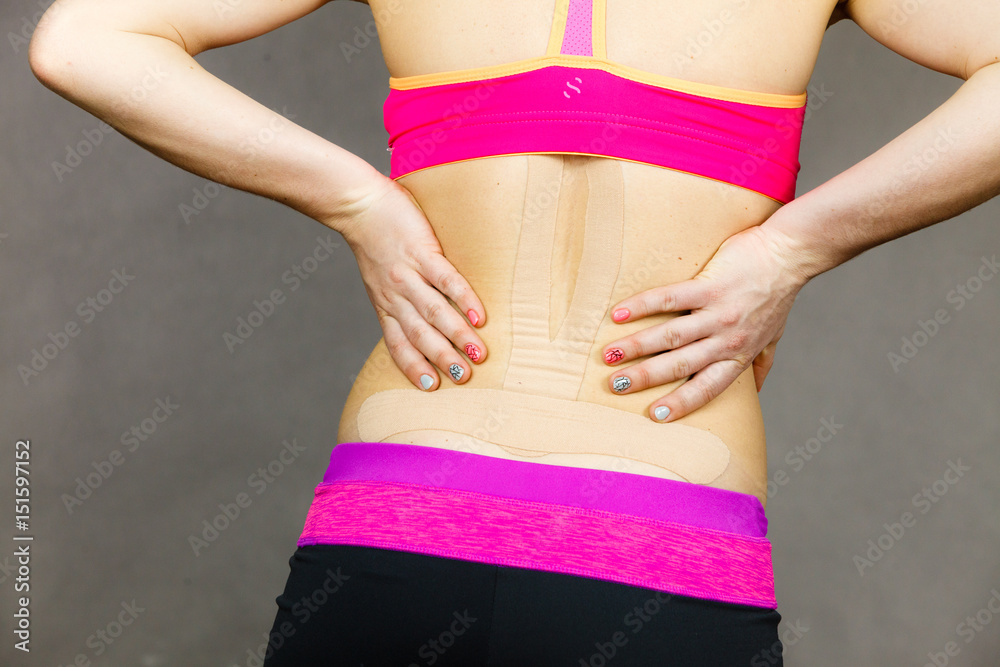 Woman with medical kinesio taping on back Woman with medical kinesio taping on back