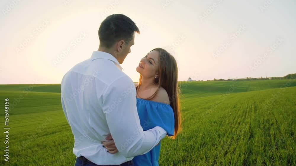 Couple in love stands in embraces, looking and kissing each other on the horizon Couple in love stands in embraces, looking and kissing each other on the horizon