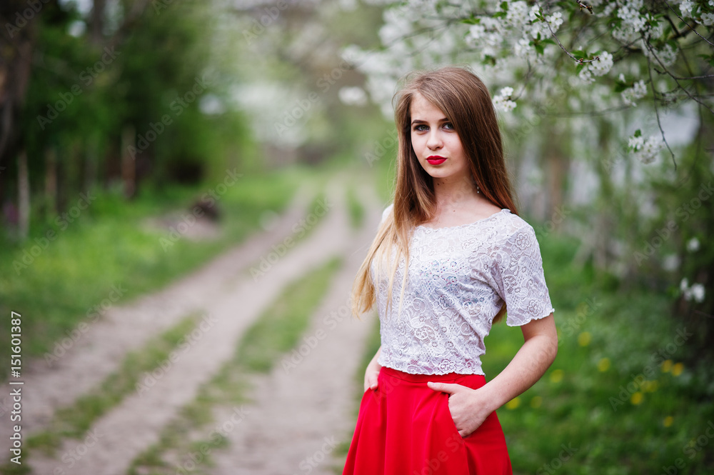 Portrait of beautiful girl with red lips at spring blossom garden, wear on red dress and white blouse. Portrait of beautiful girl with red lips at spring blossom garden, wear on red dress and white blouse.