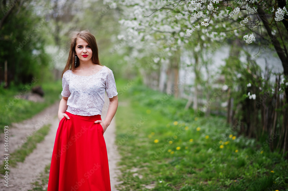 Portrait of beautiful girl with red lips at spring blossom garden, wear on red dress and white blouse. Portrait of beautiful girl with red lips at spring blossom garden, wear on red dress and white blouse.