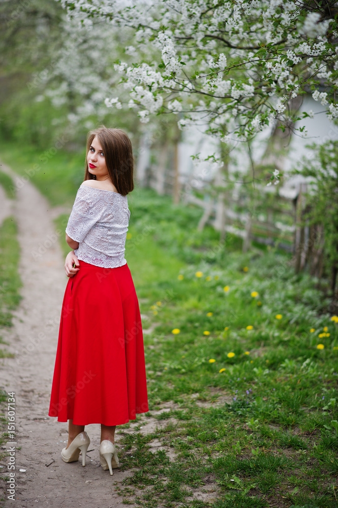 Portrait of beautiful girl with red lips at spring blossom garden, wear on red dress and white blouse. Portrait of beautiful girl with red lips at spring blossom garden, wear on red dress and white blouse.