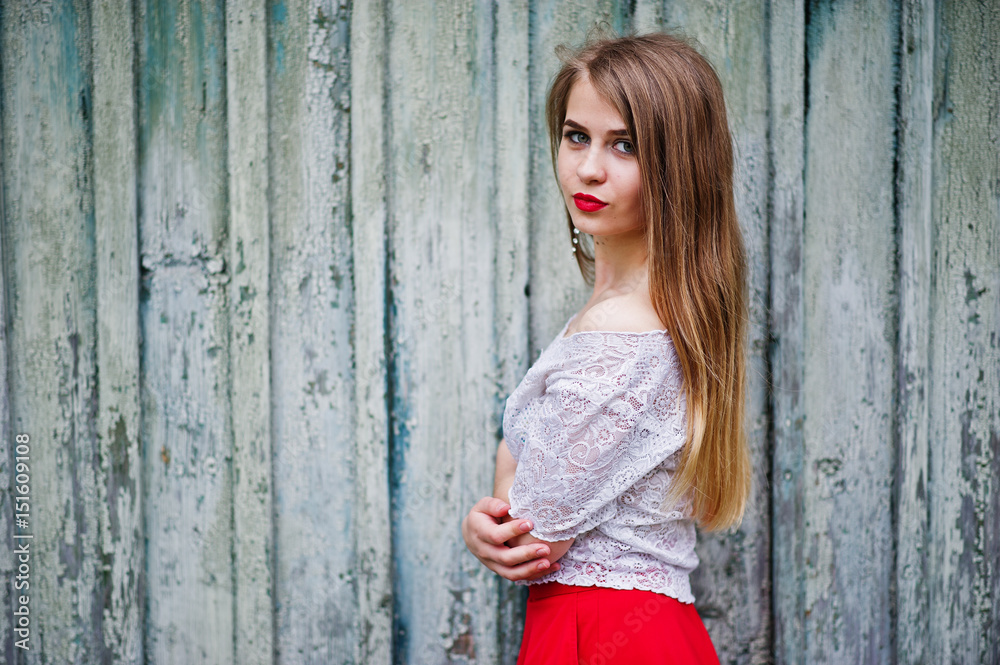 Obraz premium Portrait of beautiful girl with red lips against wooden background, wear on red dress and white blouse.
