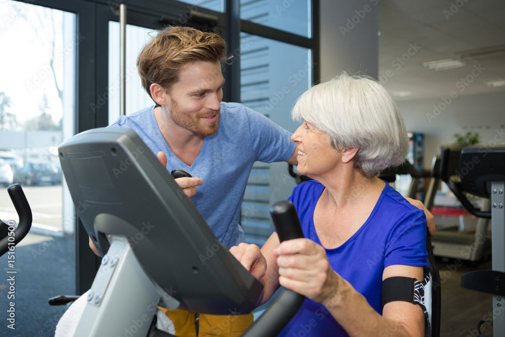 Obraz premium physiotherapist with senior woman using exercise machine