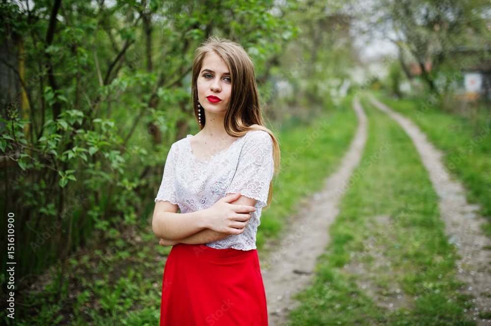Portrait of beautiful girl with red lips at spring blossom garden, wear on red dress and white blouse. Portrait of beautiful girl with red lips at spring blossom garden, wear on red dress and white blouse.