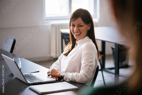 Business woman talking to her collegues in office photo