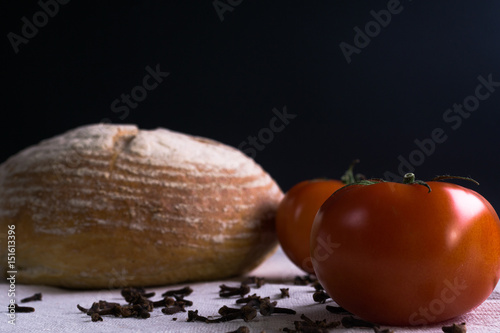 Fresh tomatoes, homemade bread and cloves. photo