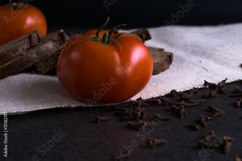 Fresh tomatoes, homemade bread and cloves. photo