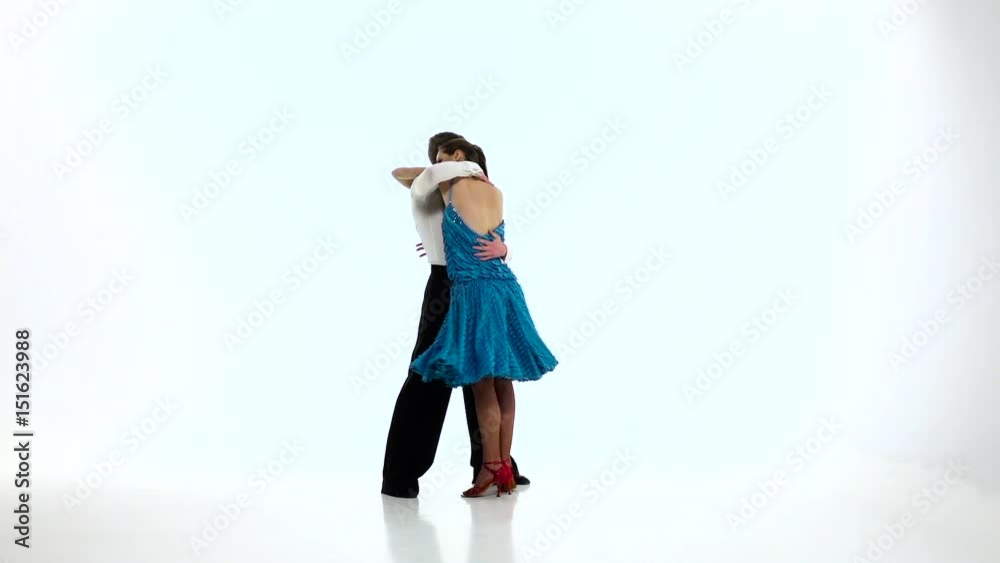 Latino dancing couple of professional elegant dancers,slow motion. White studio Latino dancing couple of professional elegant dancers,slow motion. White studio