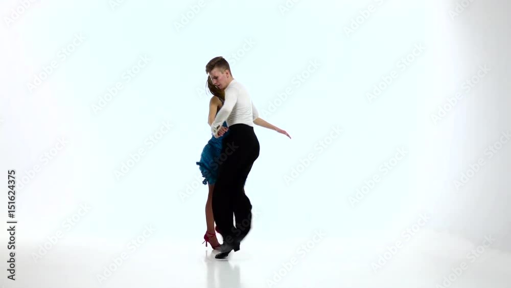 Salsa dancing couple of professional elegant dancers,slow motion. White studio Salsa dancing couple of professional elegant dancers,slow motion. White studio