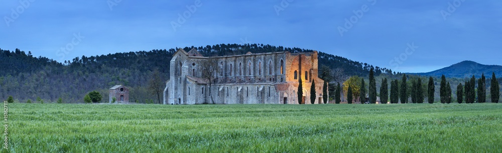 panorama with ruines of old abbay in lights in twilight time in Tuscany