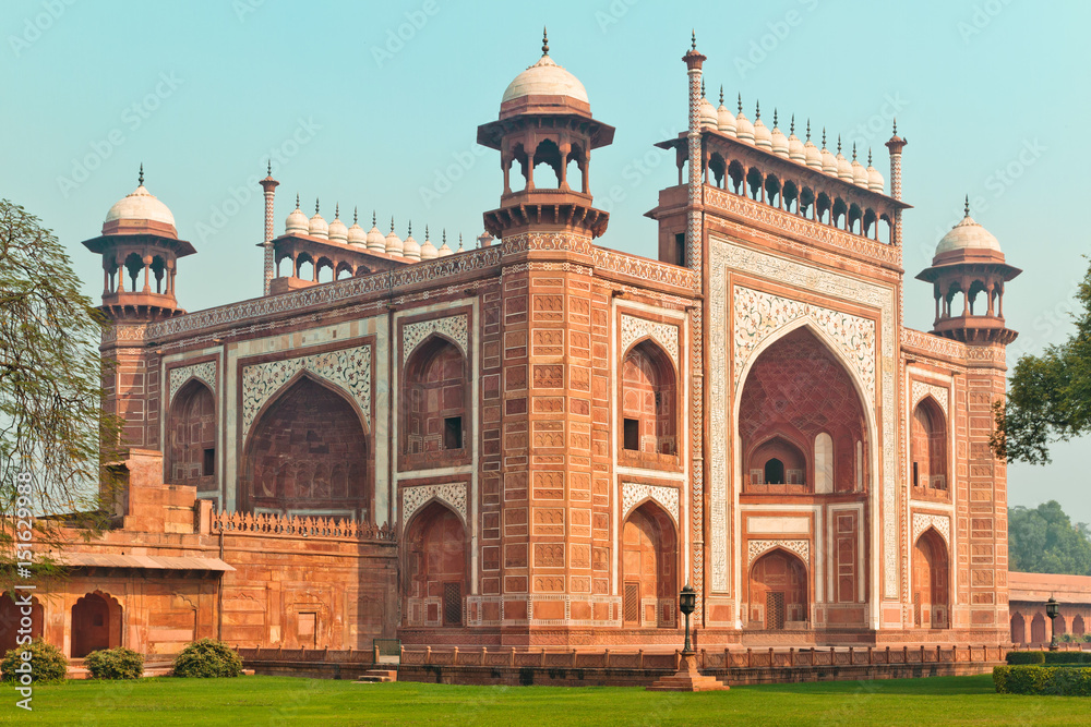 Taj Mahal Main gateway building against blue sky in Agra, Uttar Pradesh. Red sandstone masterpiece