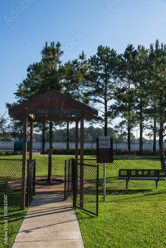 Community on-site dog park at the grassy backyard of a typical apartment complex building in suburban area at Humble, Texas, US. Off-leash dog park with pet stations, toys and bag dispensers