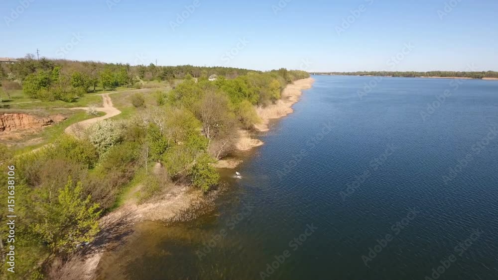 Amazing view on the Dnipro river sparkling waters and the riverbank shot from a drone flying across the river. The skyscape and horizon line look great and gorgeous in a sunny day in spring Amazing view on the Dnipro river sparkling waters and the riverbank shot from a drone flying across the river. The skyscape and horizon line look great and gorgeous in a sunny day in spring