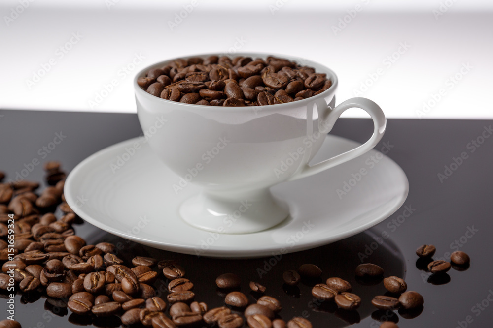 Fototapeta premium Coffee cup filled with coffee beans 