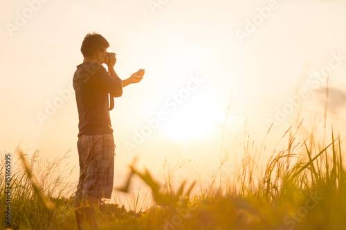 Young man is looking at sunset. Traveller with camera © releon8211