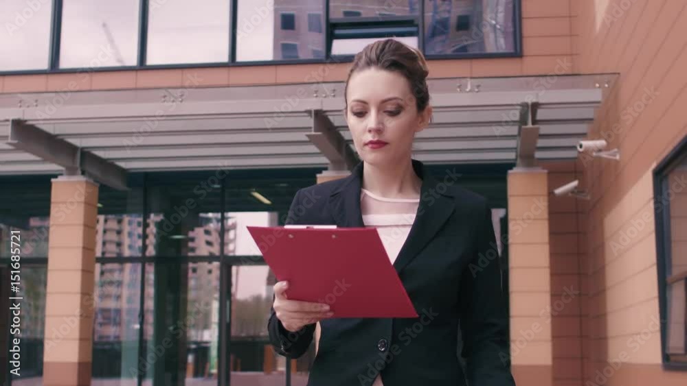 businesswoman reading documents on the go. girl in a hurry for a business meeting businesswoman reading documents on the go. girl in a hurry for a business meeting