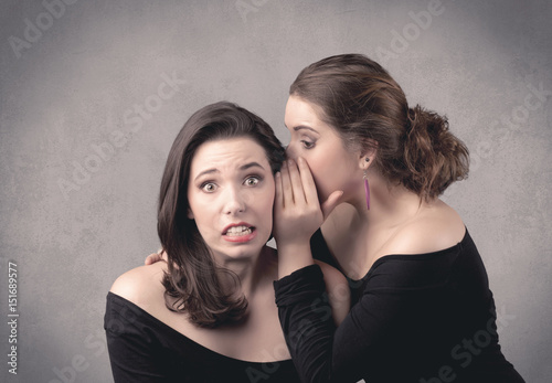 girl telling secret things to her girlfriend