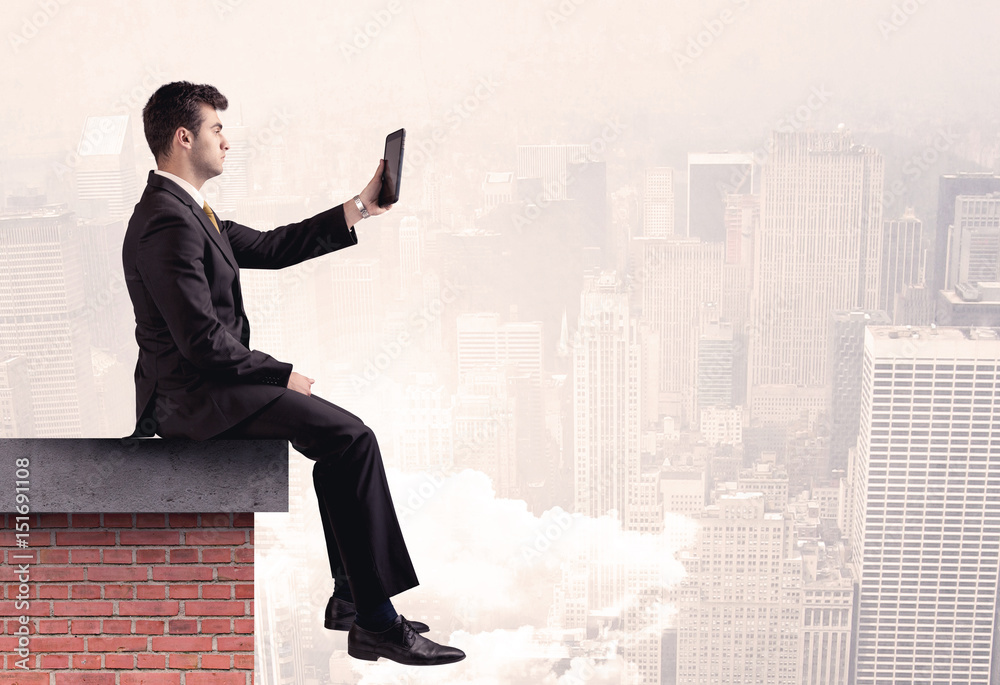 Office worker sitting on rooftop in city Office worker sitting on rooftop in city