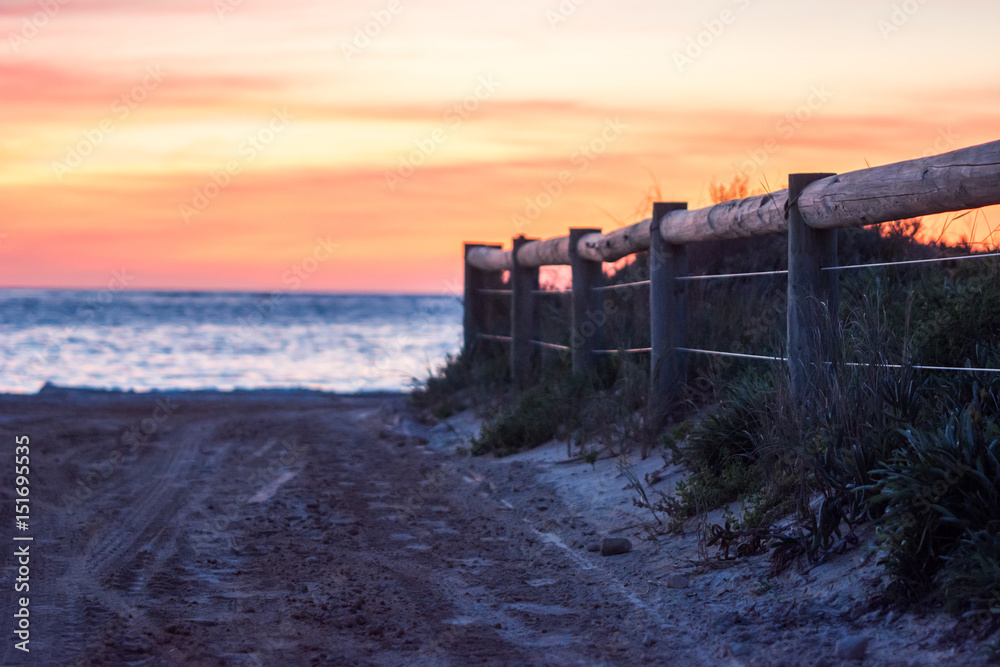 Ocean view of a pathway with a wooden fence leading you to a beautiful sky at Indian ocean on sunset. Landscape from Travel in Australia