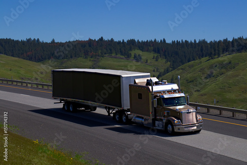 A Bronze Freightliner Semi Tractor with an extended sleeper travels along Interstate 84 in Rural Oregon on May 2nd, 2017.