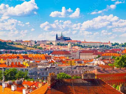 Prague panorama with Prague Castle - Hradcany and red rooftops. Sunny summer day with blue sky and white clouds, Czech Republic.