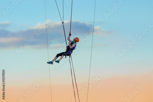 young beautiful brave woman roupejumping in the evening on the bridge