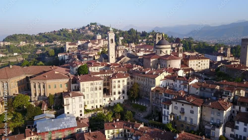 Drone aerial view of Bergamo - Old city (Città Alta). One of the beautiful city in Italy. Landscape on the city center, the main square and its historical buildings during a wonderful blu day Drone aerial view of Bergamo - Old city (Città Alta). One of the beautiful city in Italy. Landscape on the city center, the main square and its historical buildings during a wonderful blu day