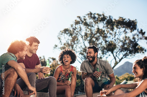 Friends enjoying and having drinks at outdoor party photo
