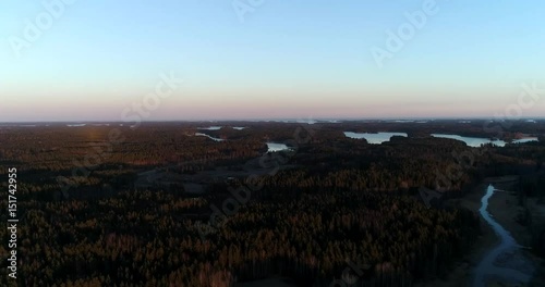 Countryside sunset, Cinema 4k aerial of the forrest, ponds and the baltic sea on the countryside of Snappertuna, Finland, on a sunny spring evening photo