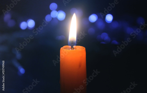 Burning candle with christmas lights 