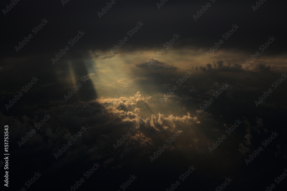 Rays of light shining through dark clouds on another cloud layer for ...