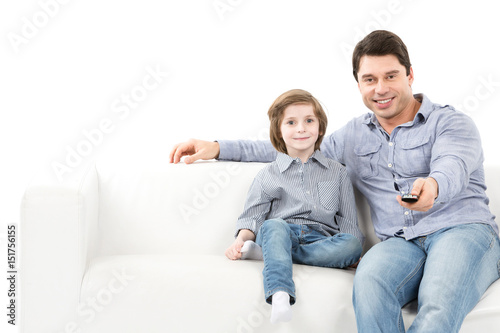 Father and son on the couch switch channels.