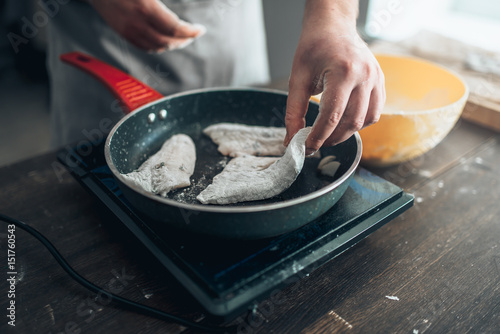 Φωτογραφία Chef cooking sea bass fish fillet on a frying pan
