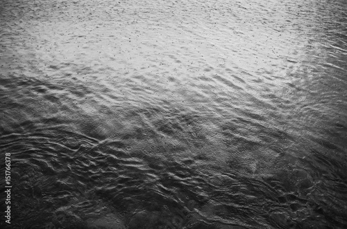 Rain drops ripples in the sea. Black and white background pattern texture.