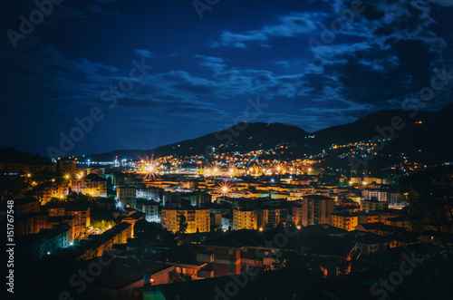 Night panoramic overview of La Spezia city, Italy. Picturesque scene with illuminated colorful buildings in moonlight.