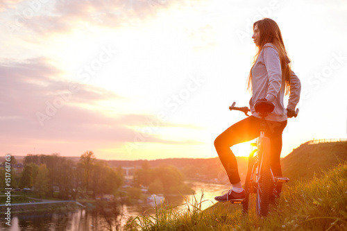 Fototapeta Naklejka Na Ścianę i Meble -  girl riding bike in sunset