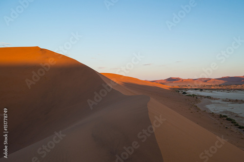 Climbing Big Daddy Dune during Sunrise with View onto Salt Pan and Desert Landscape  Sossusvlei  Namibia