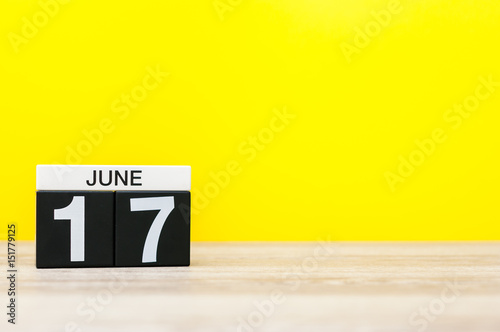 June 17th. Day 17 of month, calendar on yellow background. Summer day. Empty space for text