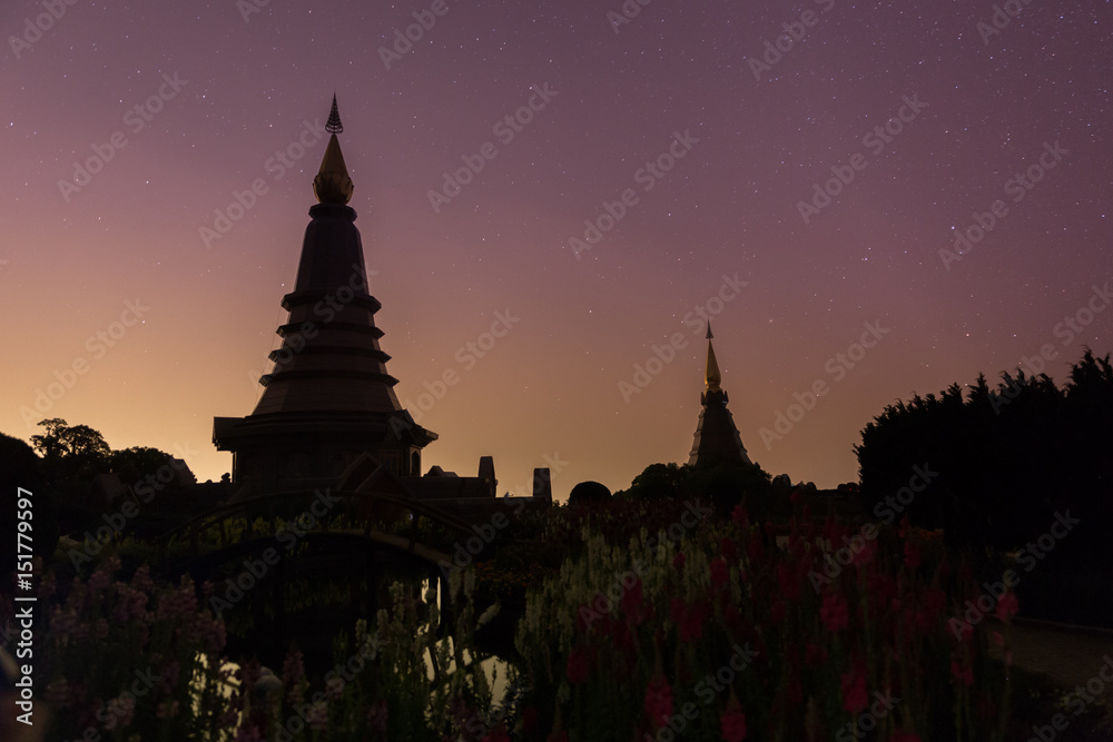 Night sky with lot of shiny stars and two pagoda in Doi Inthanon mountain, natural astronomy landscape