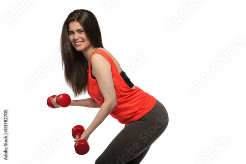 Beautiful young smiling sporty fitness woman with dumbbells