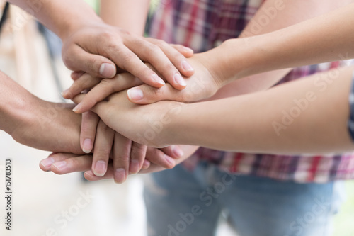 young college student joining hand, business team touching hands together - unity, harmony, teamwork, friends concept