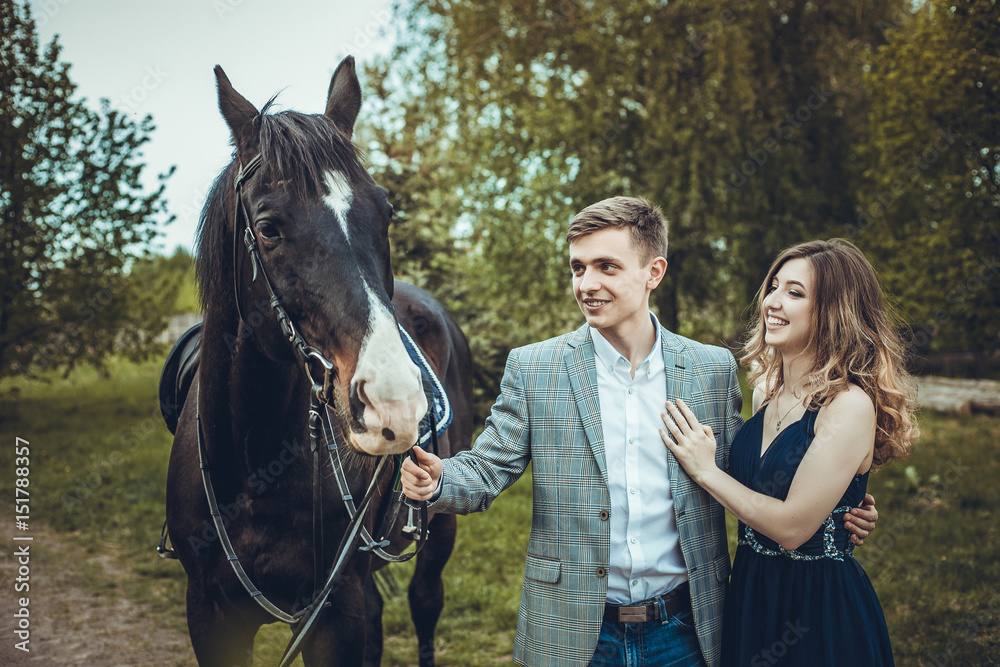 Fototapeta premium Couple in love walking in the woods with a horse.