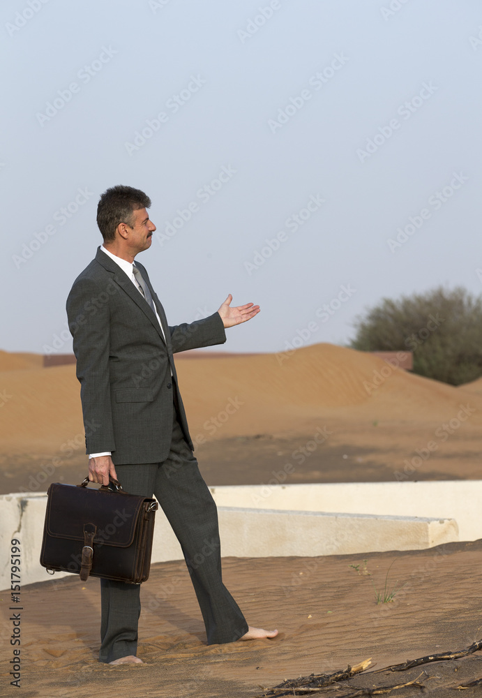 businessman with a briefcase in a desert village, pointing at a old house in a sand businessman with a briefcase in a desert village, pointing at a old house in a sand