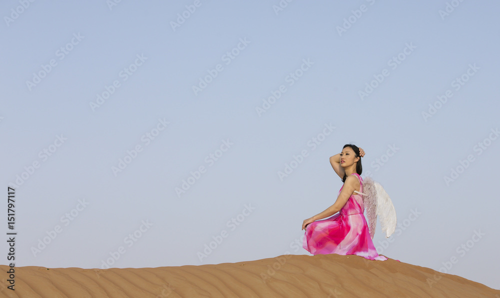 young woman with angel wings in a desert