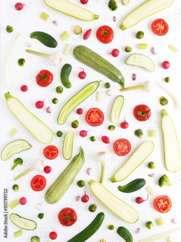 Fototapeta Świeże warzywa w kawałku na białym tle. Wzór z warzyw. Tło żywności. Ogórki, pomidory i cukinia w kawałku.